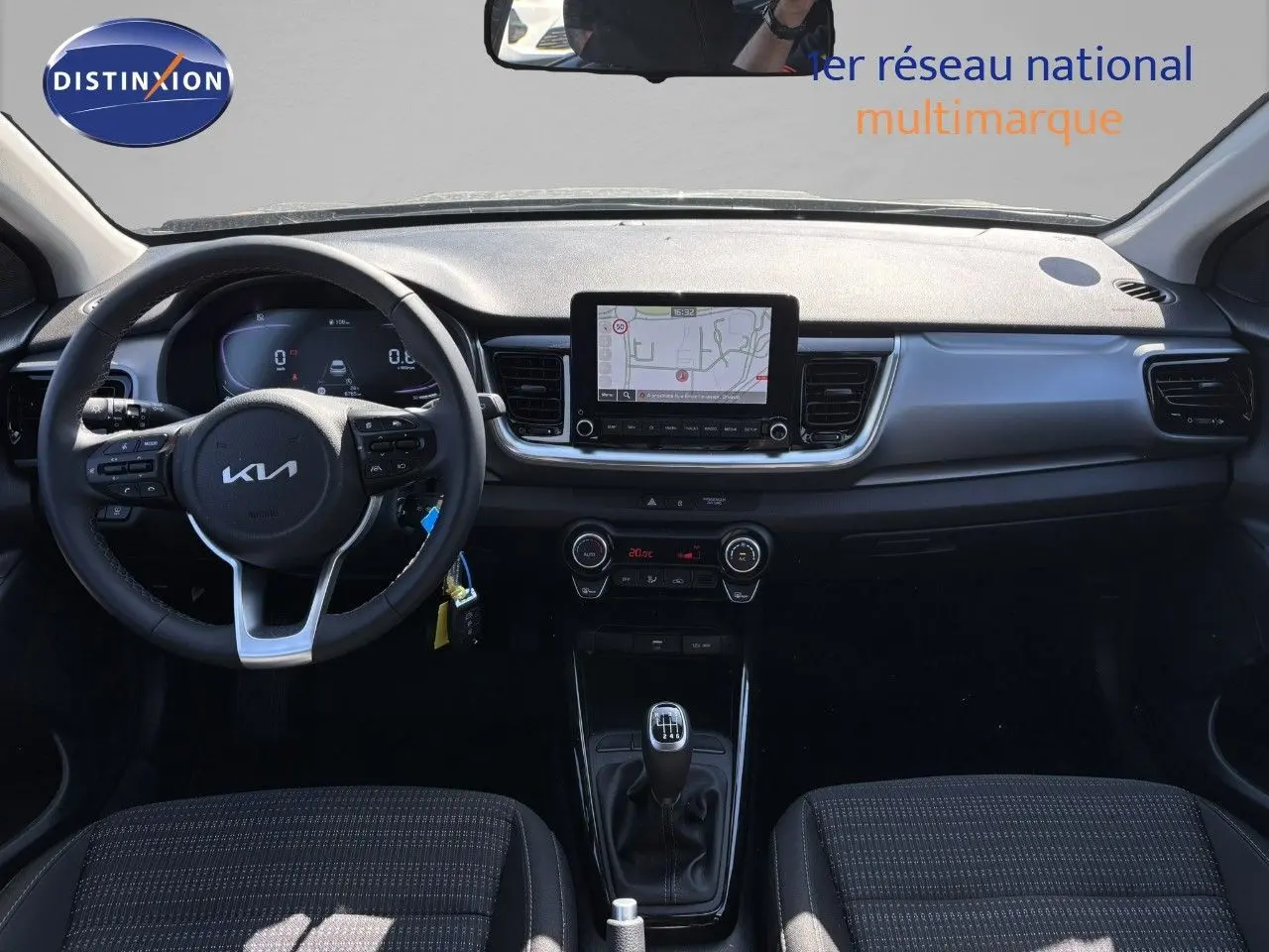 Vue intérieure avant du Kia Stonic 2024 essence gris météore, tableau de bord avec écran tactile et boîte manuelle.