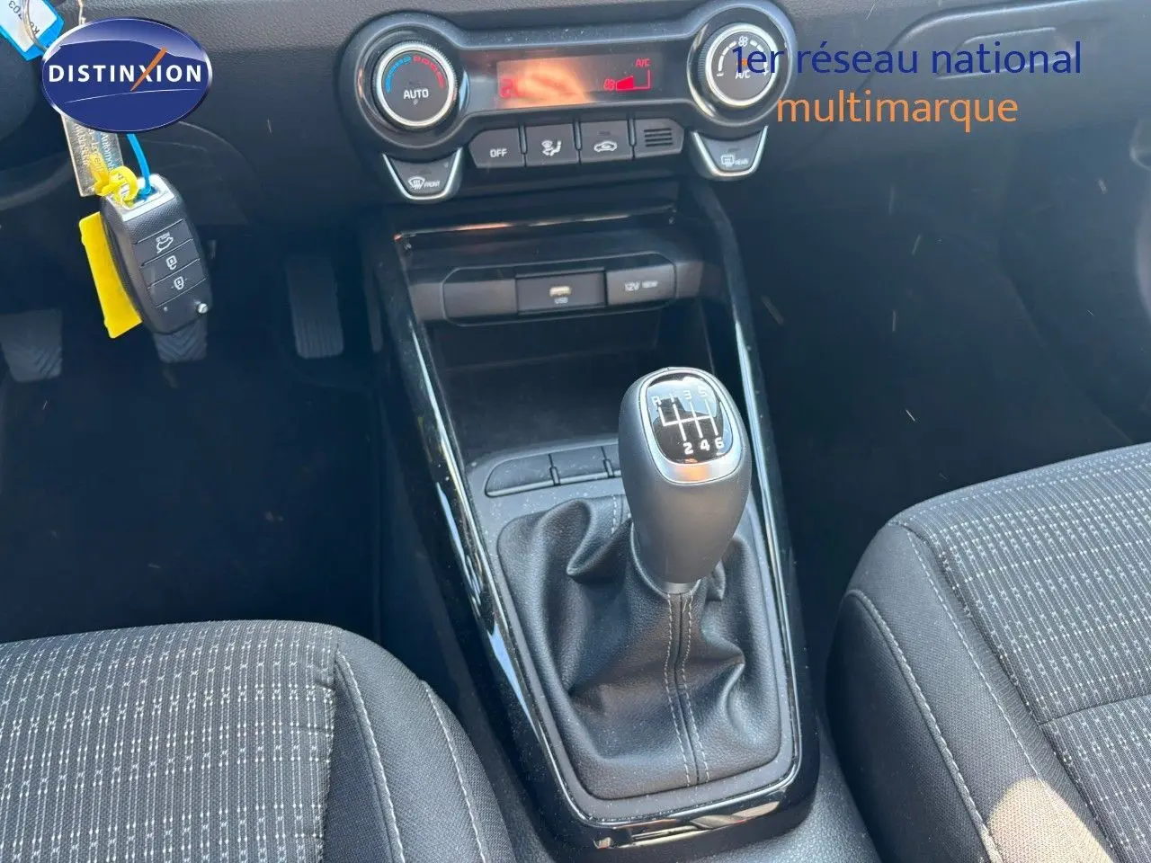 Le levier de vitesses manuel du Kia Stonic 2024 en vue rapprochée, avec console centrale et sièges en tissu noir.