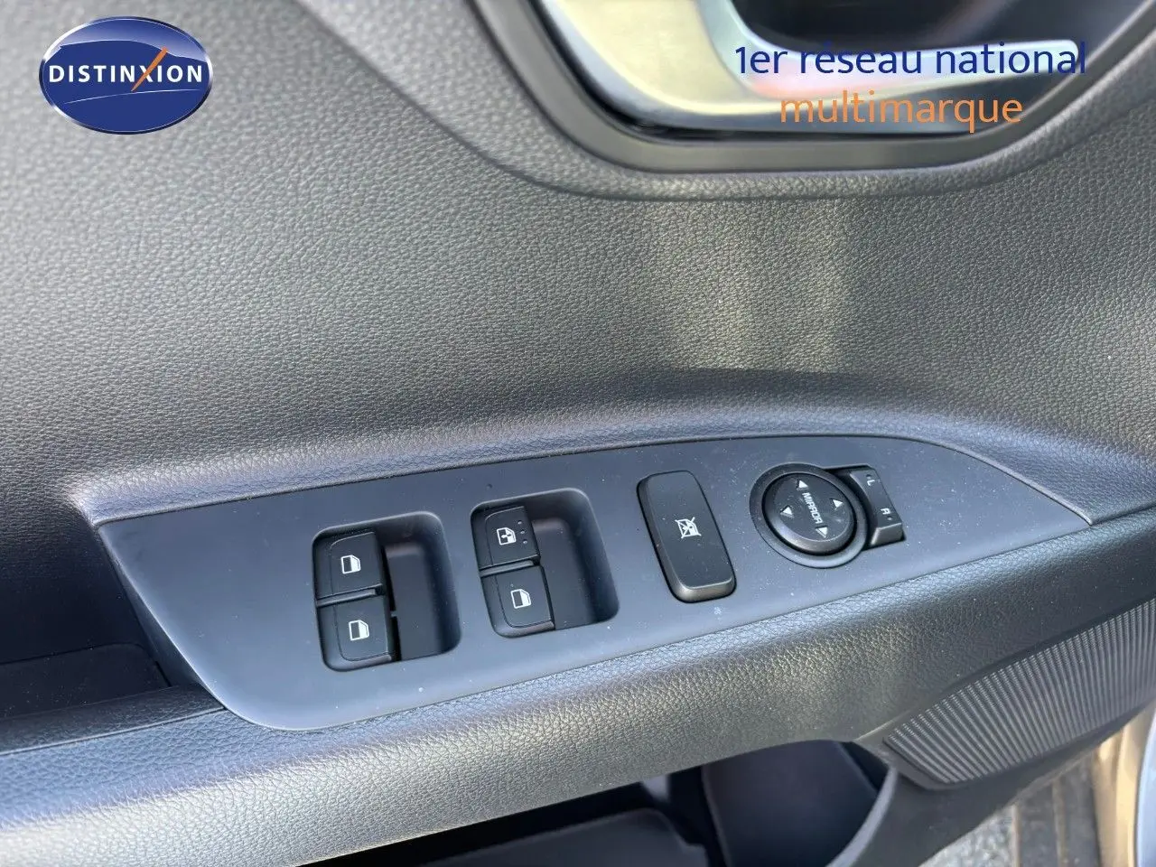 Gros plan sur les commandes de lève-vitres et rétroviseurs côté gauche d'une KIA STONIC gris météore 2024.