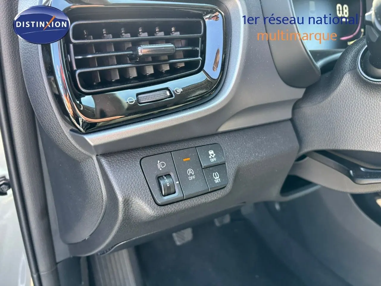 Détail du tableau de bord côté gauche du Kia Stonic gris météore 2024 avec commandes d'éclairage et sécurité.