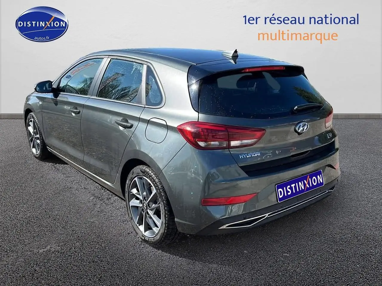 Vue 3/4 arrière droit d'une Hyundai i30 gris argent 2024 avec jantes alliage et vitres arrière surteintées.