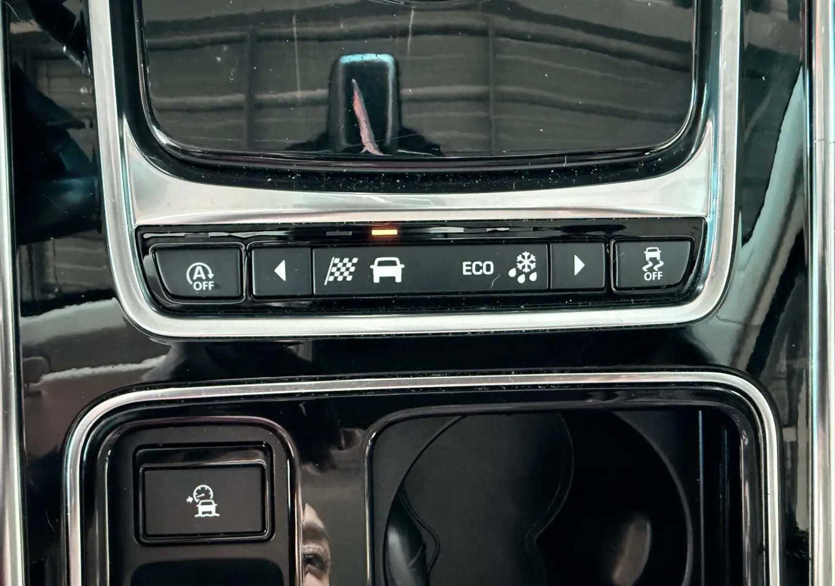 Gros plan sur la console centrale noire de la Jaguar XE 2019 montrant les boutons de modes de conduite et contrôle de stabilité.