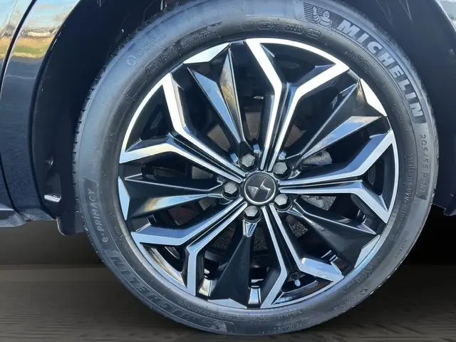 Gros plan sur la jante noire et argentée au design géométrique du DS4 2022 noir, équipée d'un pneu Michelin.