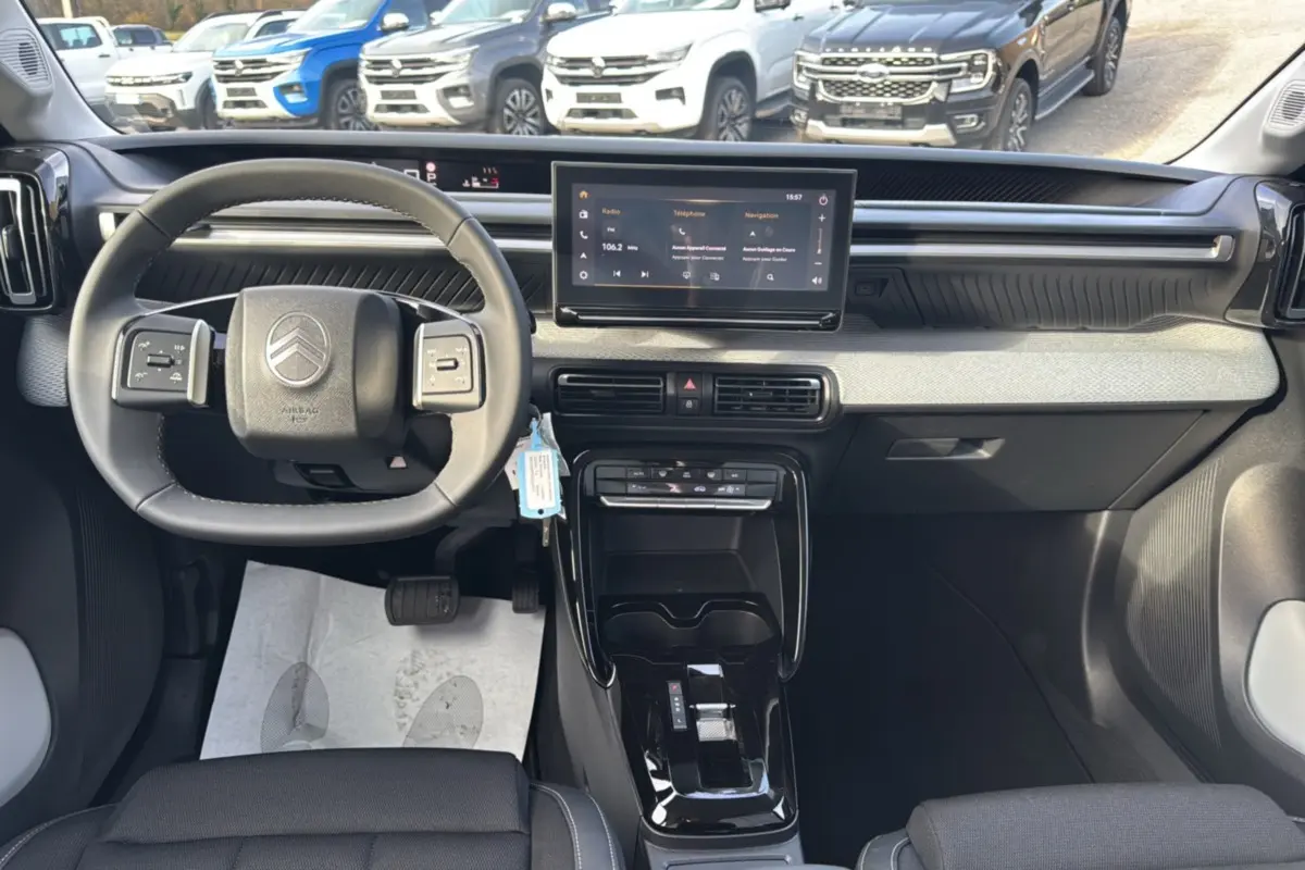 Vue intérieure frontale du tableau de bord et volant cuir noir du Citroën C3 Aircross Hybrid 145 2025.