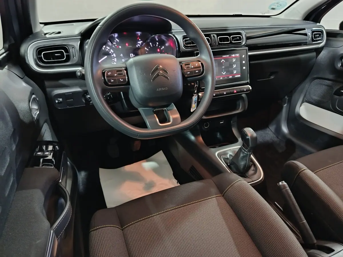 Vue intérieure avant de la Citroën C3 PureTech 83 BVM MAX 2024, tableau de bord noir avec écran tactile et volant multifonctions.