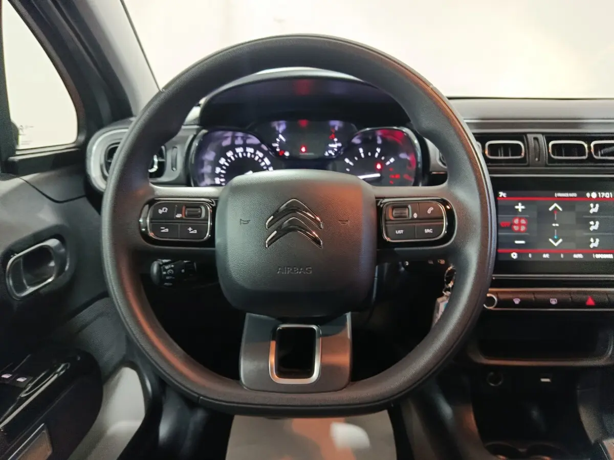 Vue frontale du volant et tableau de bord de la Citroën C3 2024, avec écran tactile et commandes au volant visibles.