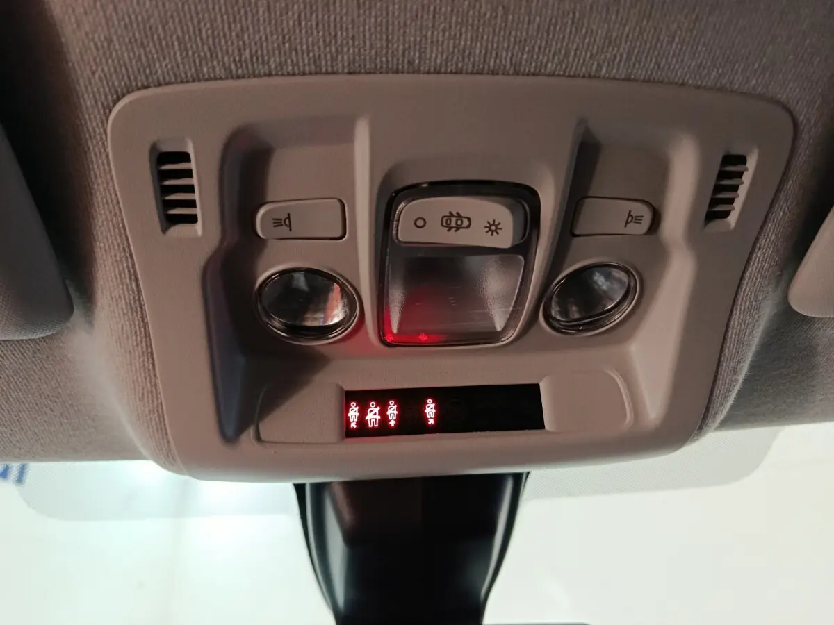 Vue en gros plan du plafonnier intérieur gris clair de la Citroën C3 avec commandes d’éclairage et indicateurs rouges allumés.