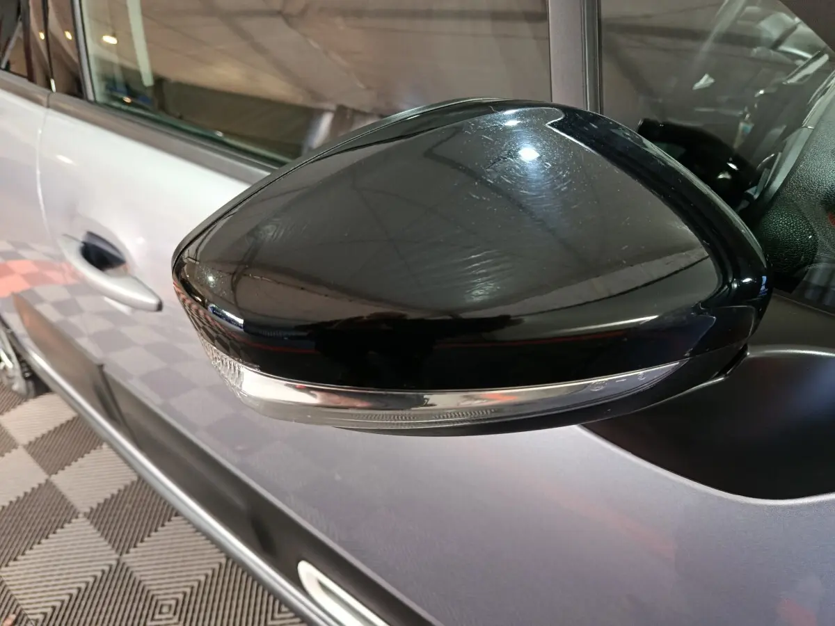 Gros plan sur le rétroviseur droit noir brillant de la Citroën C3 gris foncé 2024, avec clignotant intégré.