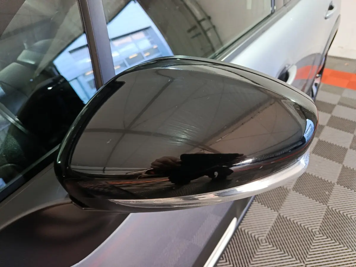 Rétroviseur droit noir brillant de Citroën C3 gris foncé, avec clignotant intégré, vue rapprochée côté passager.
