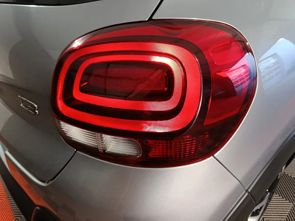 Gros plan sur le feu arrière droit rouge et blanc d'une Citroën C3 gris foncé 2024, avec logo C3 visible.