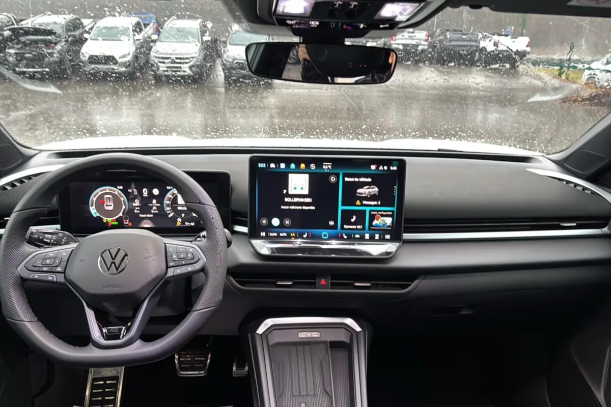Vue intérieure avant du Volkswagen T-Roc 2026, tableau de bord noir avec écran tactile central et volant multifonctions.