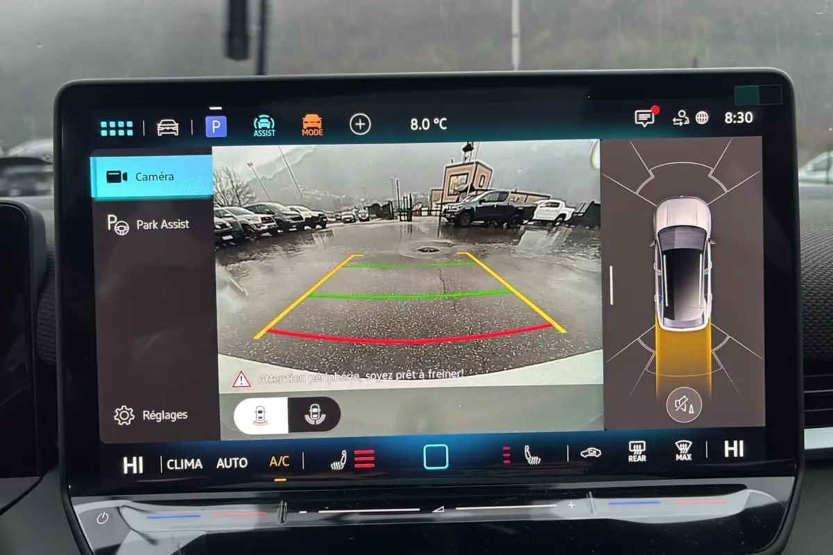 Écran intérieur affichant la caméra de recul et l’aide au stationnement du Volkswagen T-Roc blanc toit noir.