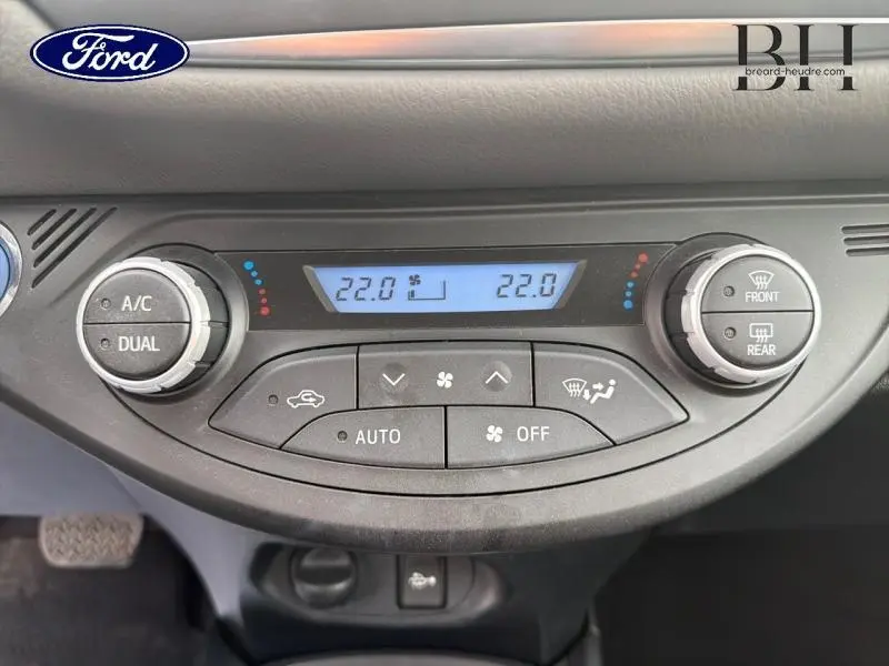 Panneau de commande de climatisation d'une Toyota Yaris 116h blanche, affichant 22°C en mode automatique.