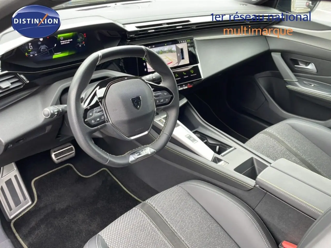Intérieur noir de la Peugeot 408 Hybrid 145ch GT 2024, vue côté conducteur sur le volant et la console centrale moderne.