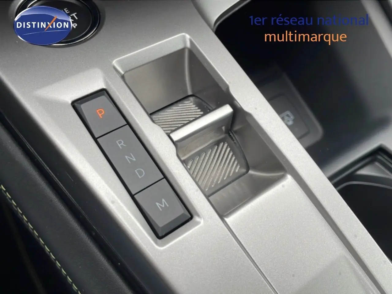 Gros plan sur la commande de boîte automatique argentée de la Peugeot 408 Hybrid 145ch GT, intérieur noir.