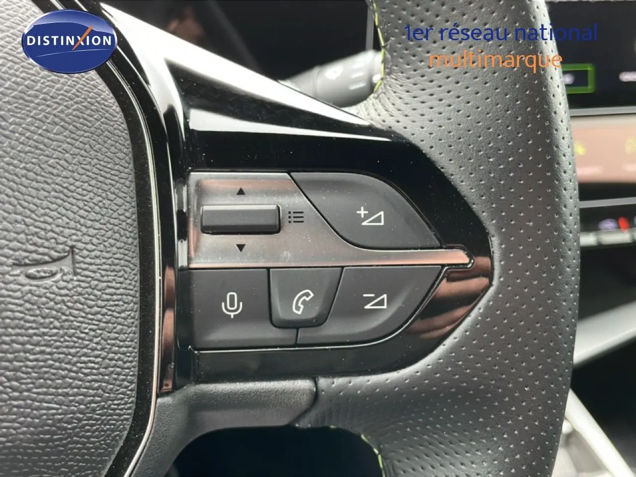 Gros plan sur les commandes au volant en cuir perforé noir de la Peugeot 408 Hybrid 145ch GT 2024.