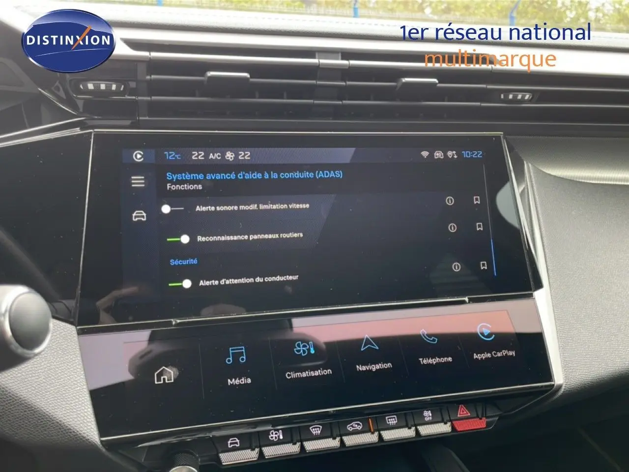 Vue rapprochée de l’écran tactile central du Peugeot 408 Hybrid 145ch GT 2024, affichant les aides à la conduite et les options multimédia.