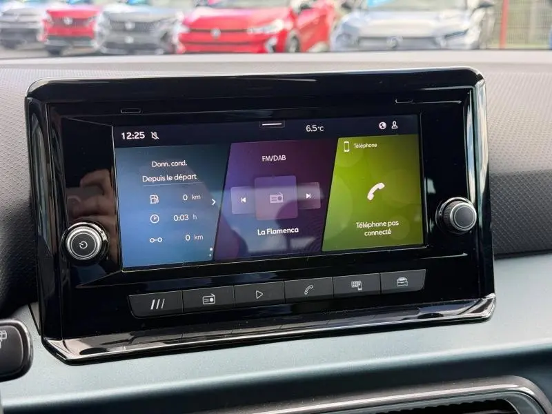 Écran tactile central du tableau de bord du SEAT Arona 2025, affichant radio FM/DAB et menu téléphone.
