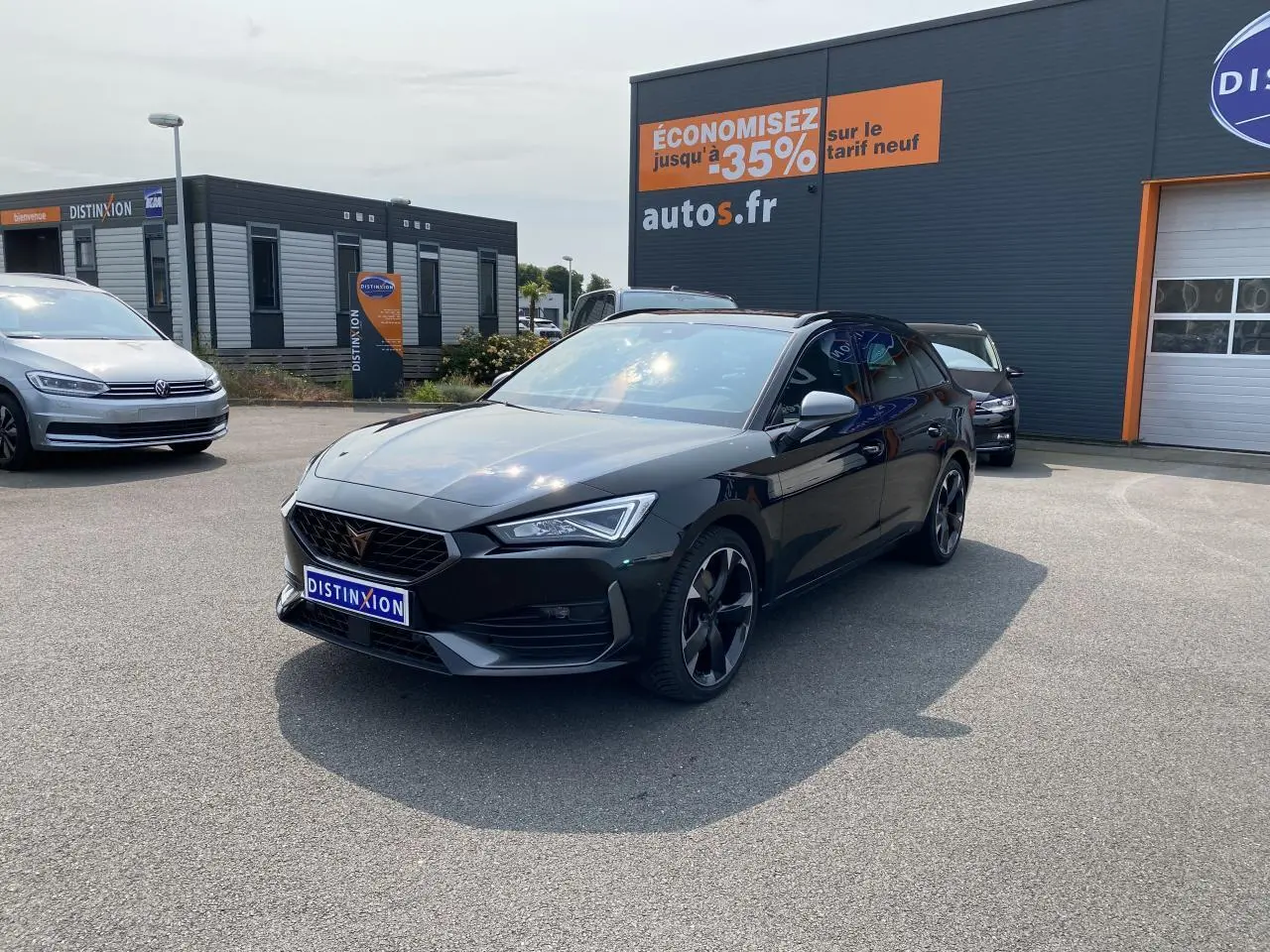 Vue 3/4 avant d'une CUPRA LEON ST 2024 noire Midnight avec jantes noires et calandre distinctive en concession.