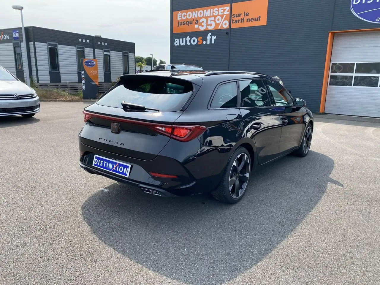 Vue 3/4 arrière droite d'une CUPRA LEON ST noire Midnight avec feux Tri-LED et jantes sport noires.