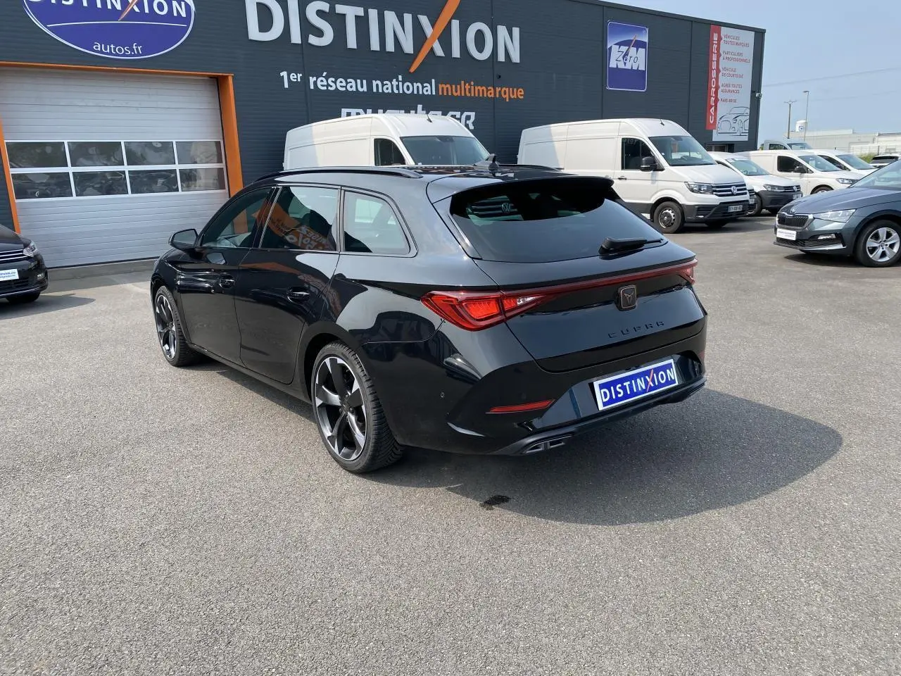 Vue 3/4 arrière droite d'une CUPRA LEON ST noire Midnight avec feux LED et jantes alliage distinctives.