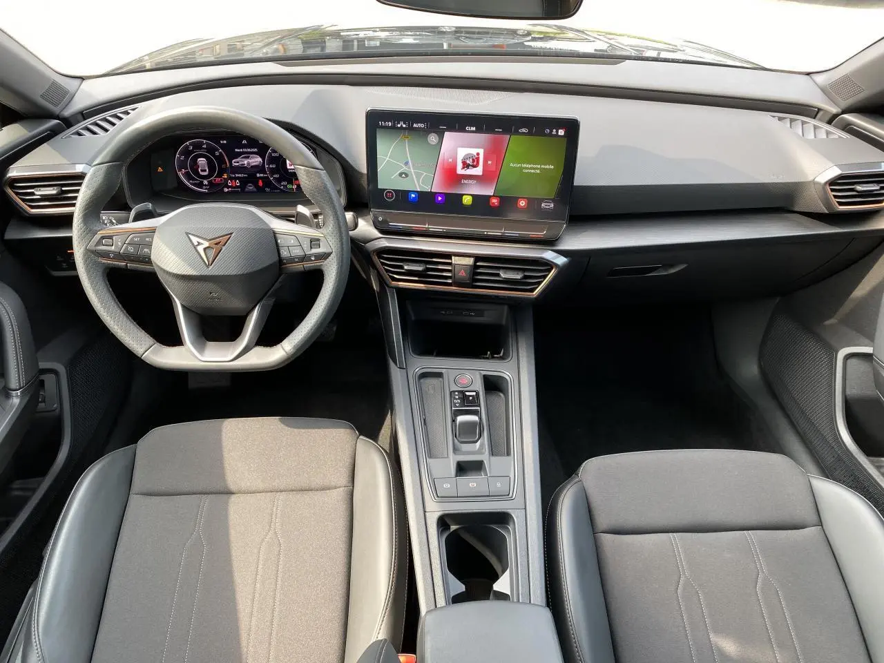 Intérieur de la CUPRA LEON ST 2024 noir Midnight, vue frontale du poste de conduite avec écran tactile et volant multifonction.