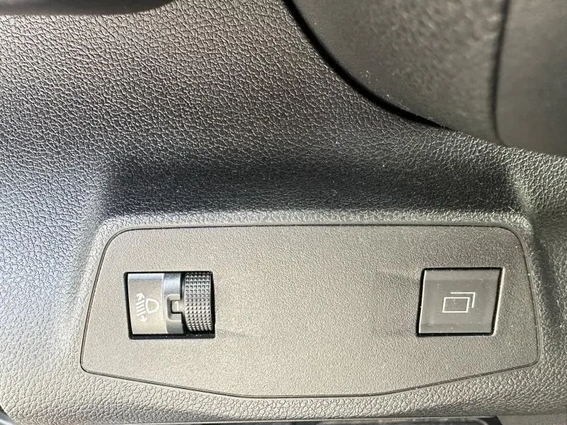 Gros plan sur les commandes d'éclairage intérieur du Citroën Berlingo gris Artense, texture plastique noire.