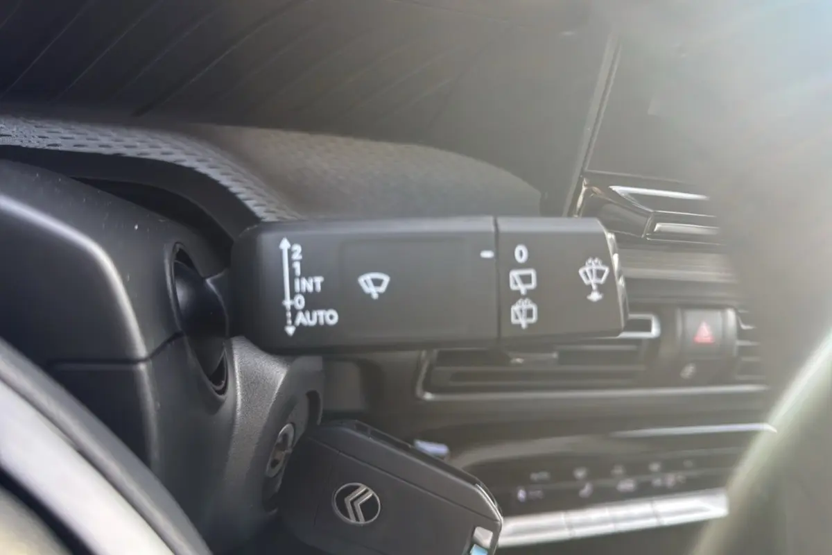 Gros plan sur la commande d’essuie-glace du Citroën C3 Aircross noir perla nera, intérieur lumineux et moderne.