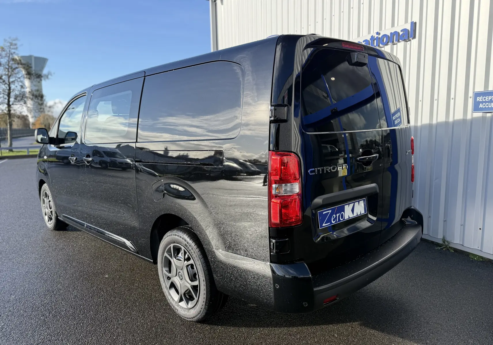 Vue 3/4 arrière droite d’un Citroën Jumpy Cabine Approfondie XL noir perla avec vitres arrière teintées et jantes spécifiques.