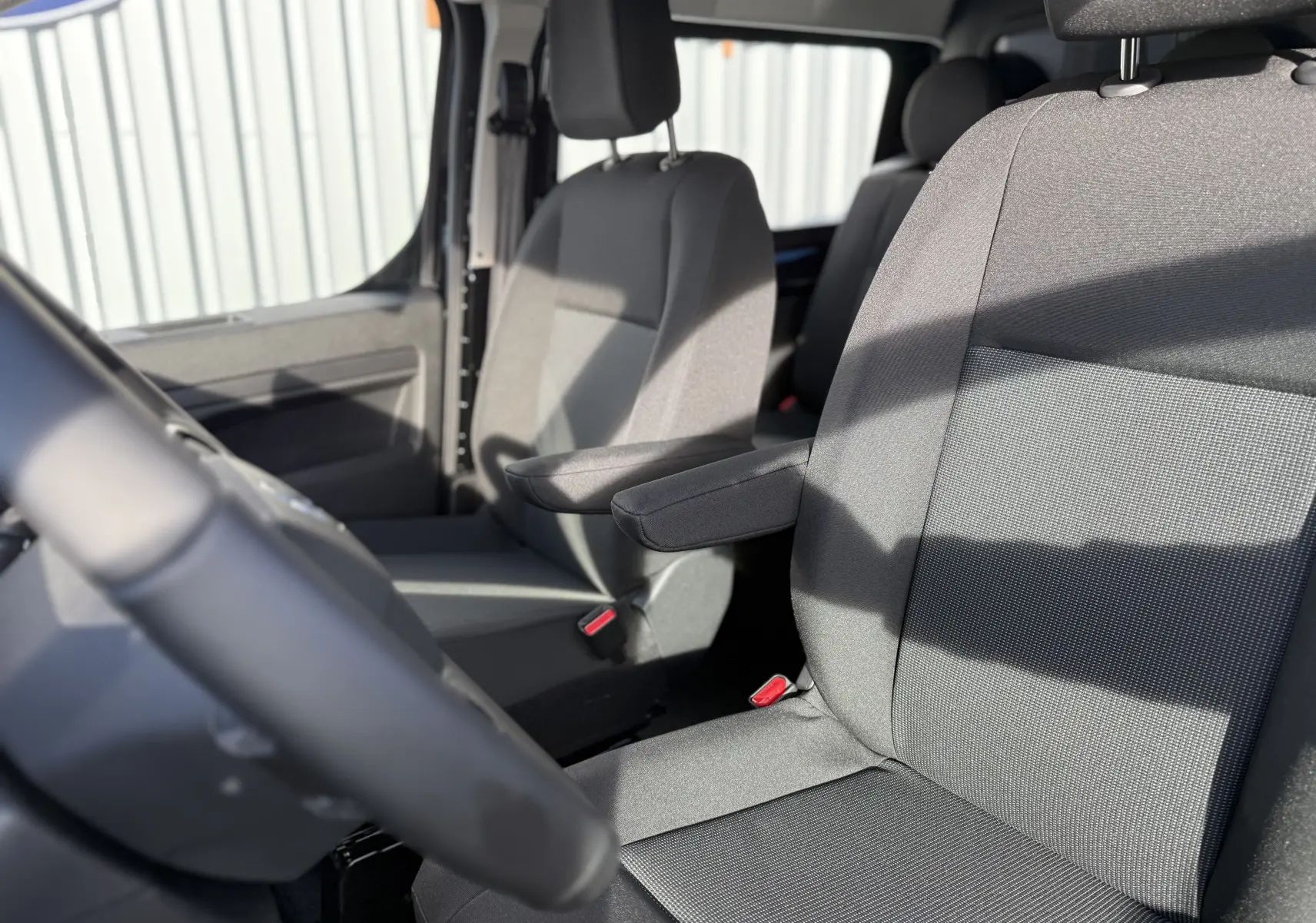 Vue intérieure rapprochée des sièges avant en tissu gris du Citroën Jumpy Cabine Approfondie XL noir Perla 2025.