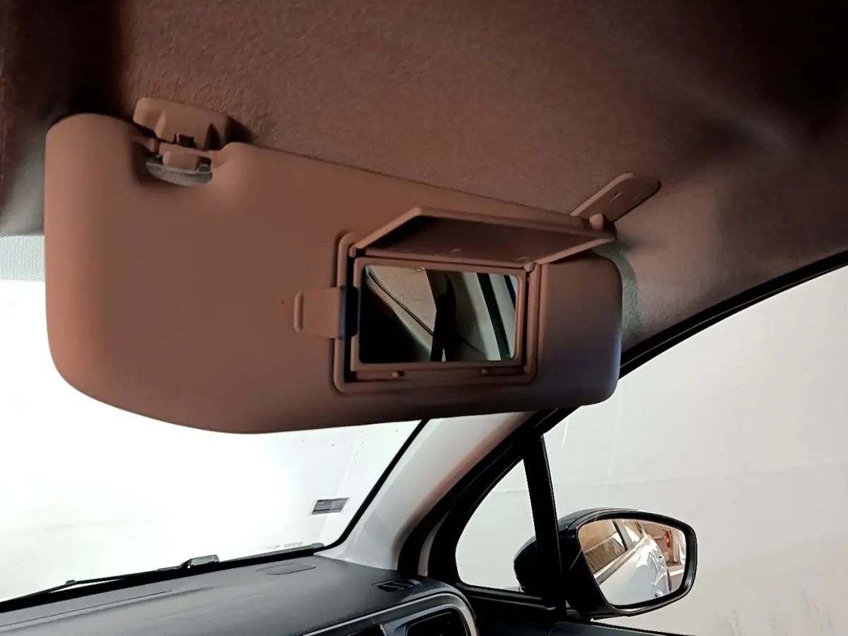 Vue intérieure du pare-soleil côté conducteur avec miroir de courtoisie ouvert dans une Citroën C3 blanche.