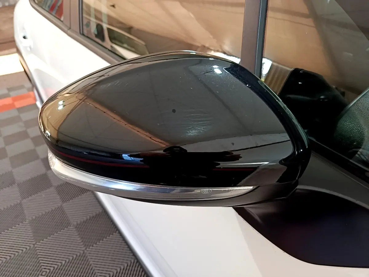 Rétroviseur extérieur droit noir brillant avec clignotant intégré sur Citroën C3 blanche vue de côté.