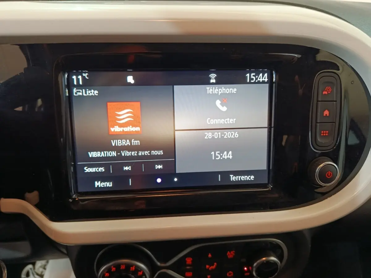 Écran tactile central allumé de la Renault Twingo Zen 2021, entouré de cadre blanc et commandes noires.