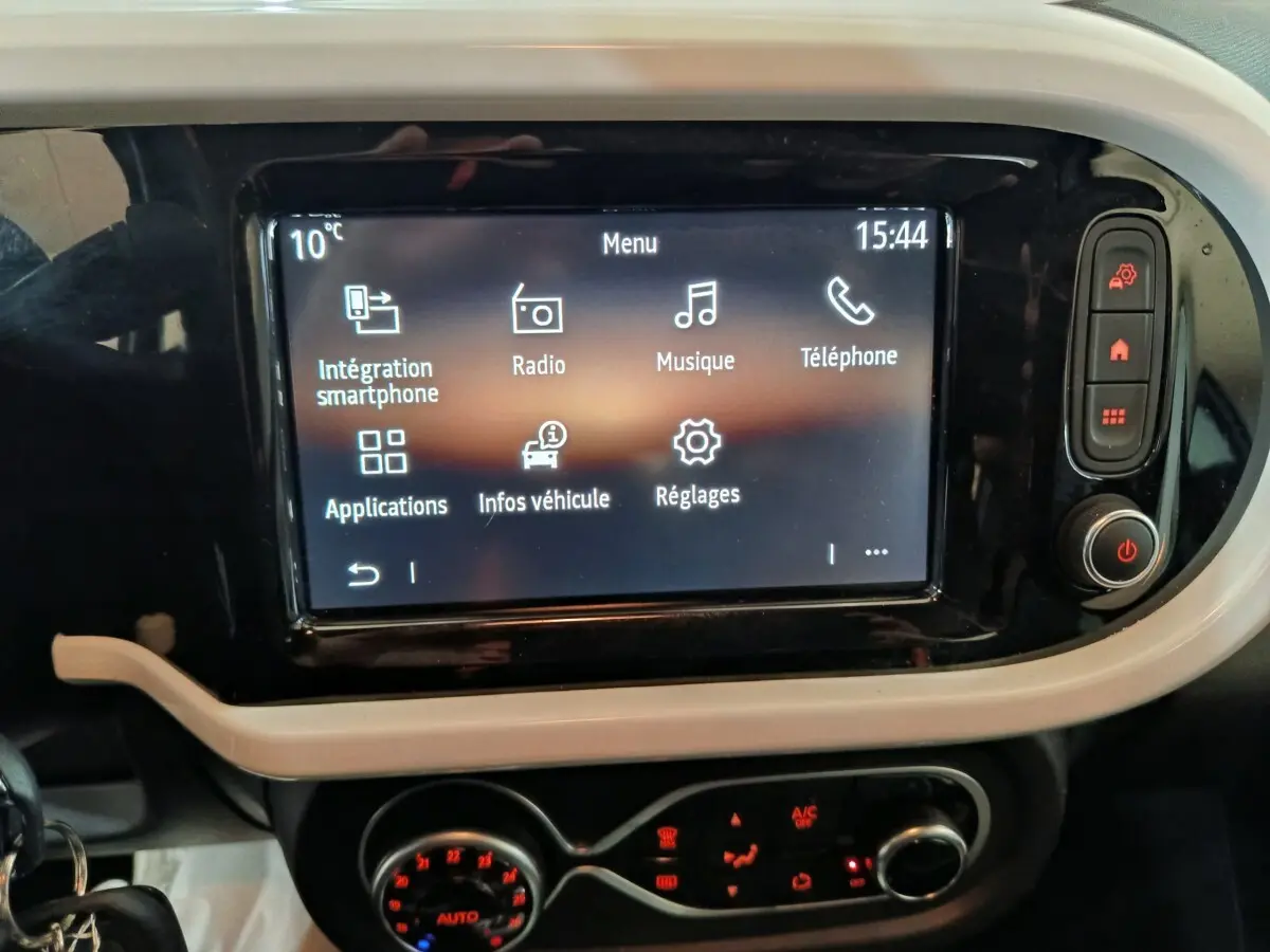 Écran tactile central affichant le menu multimédia dans l’habitacle de la Renault Twingo Zen blanc, vue de face.