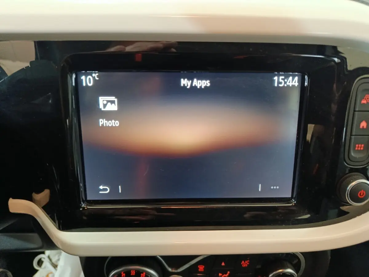 Écran tactile central allumé dans l’habitacle de la Renault Twingo Zen blanc, vue rapprochée du tableau de bord.