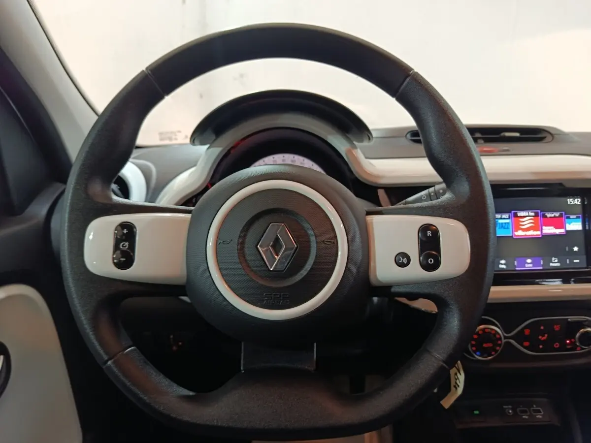 Vue centrée sur le volant noir et blanc de la Renault Twingo Zen 2021 avec tableau de bord et écran tactile visible.