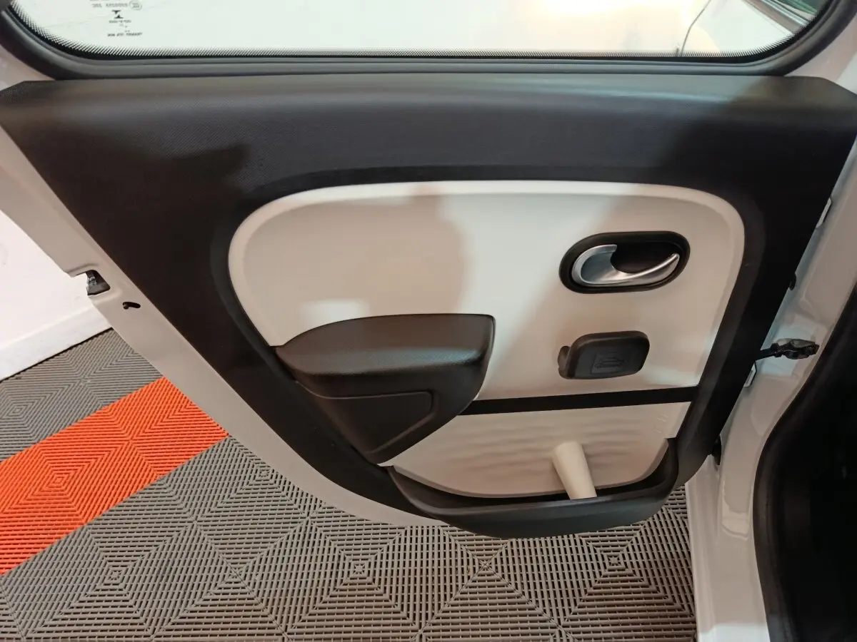 Vue intérieure de la porte arrière droite blanche d'une Renault Twingo Zen 2021 avec poignée et accoudoir noirs.