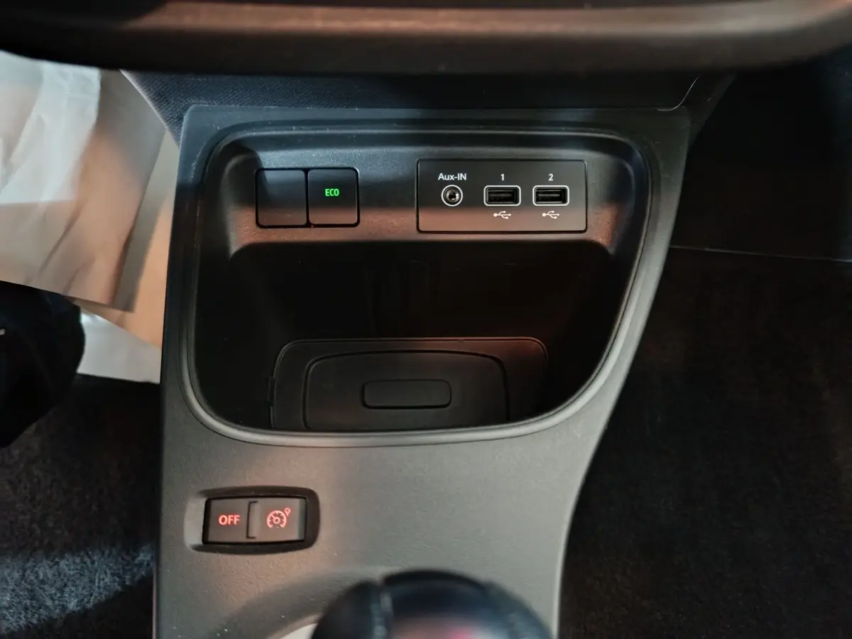Vue rapprochée du compartiment central avec prises USB et bouton ECO sur Renault Twingo Zen blanc 2021 électrique.