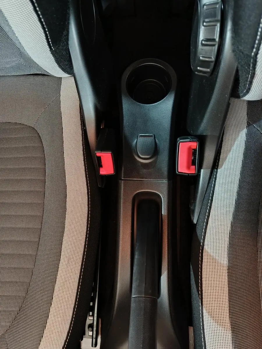 Vue plongeante sur la console centrale noire entre les sièges tissu gris de la Renault Twingo Zen électrique 2021.