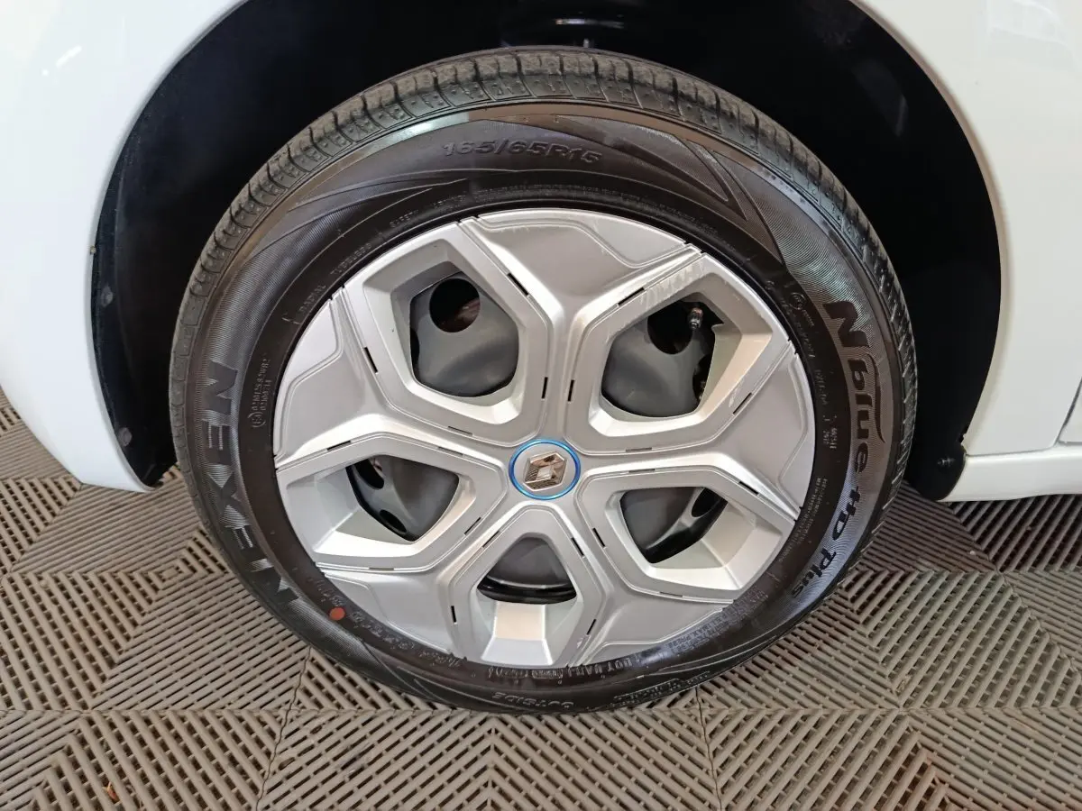 Gros plan sur la roue arrière droite blanche d'une Renault Twingo Zen électrique 2021, avec pneu Nexen visible.