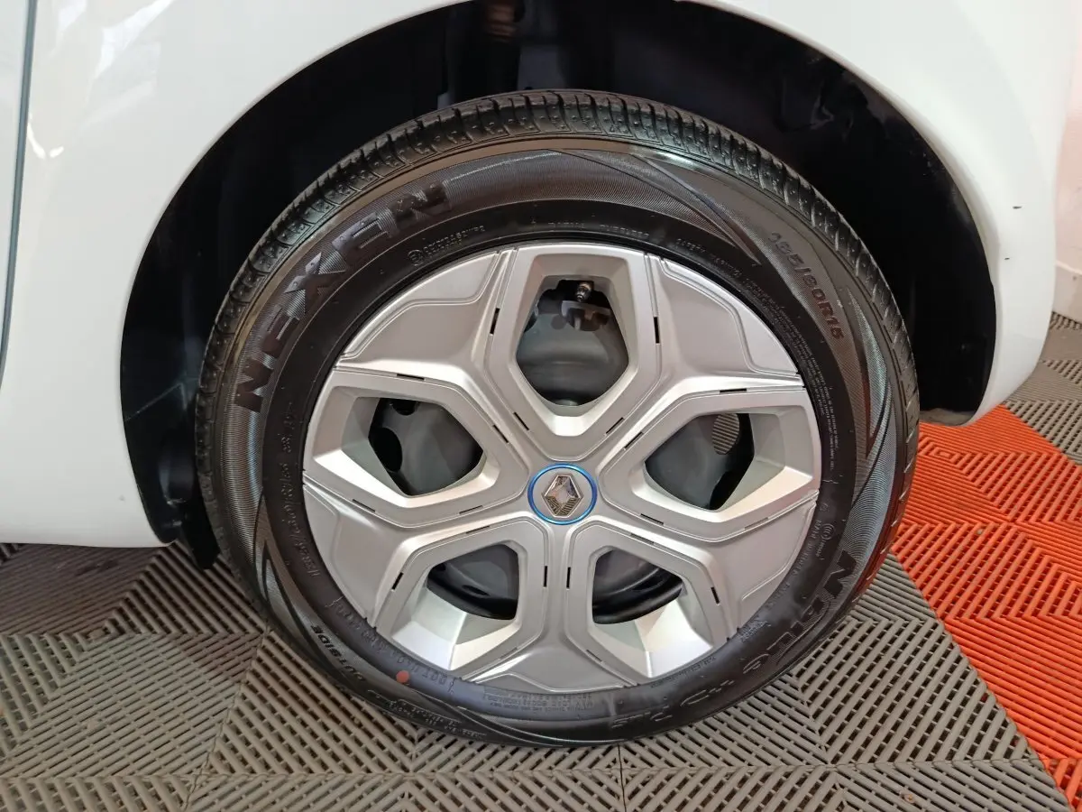Gros plan sur la roue avant droite blanche d'une Renault Twingo Zen électrique, avec jante argentée et pneu Nexen.
