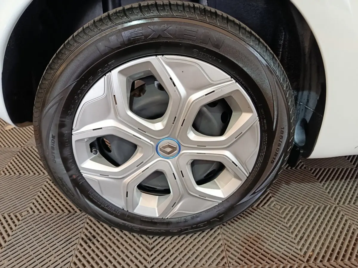 Gros plan sur la roue arrière droite d'une Renault Twingo Zen blanche de 2021, avec partie de la carrosserie visible.