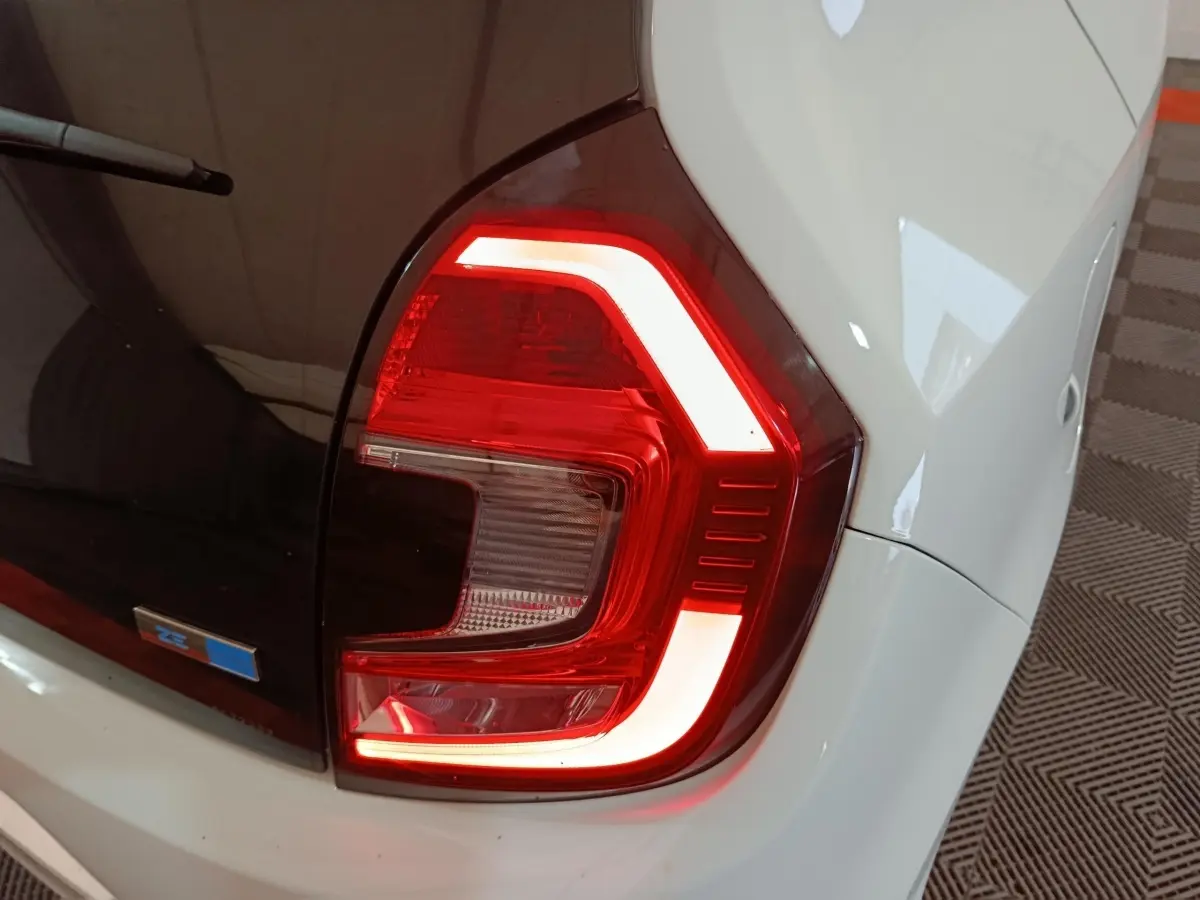 Feu arrière droit allumé sur Renault Twingo Zen électrique blanche, vue rapprochée du coin arrière droit.