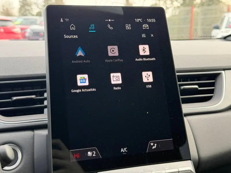 Écran tactile central du tableau de bord du Renault Captur 2025, affichant les options multimédia et climatisation.