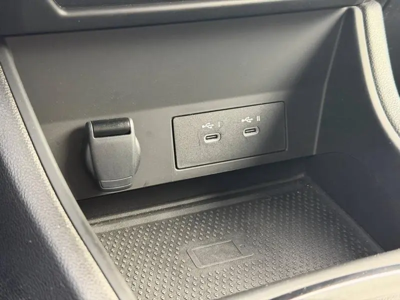 Gros plan sur la console centrale du Renault Captur 2025 montrant deux ports USB-C et une prise 12V, surface noire texturée.