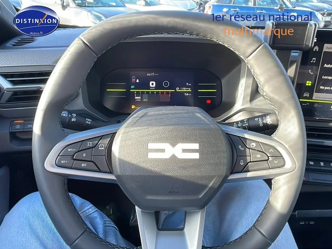 Vue intérieure centrée sur le volant cuir noir multifonction du Dacia Duster 2026 avec tableau de bord numérique.