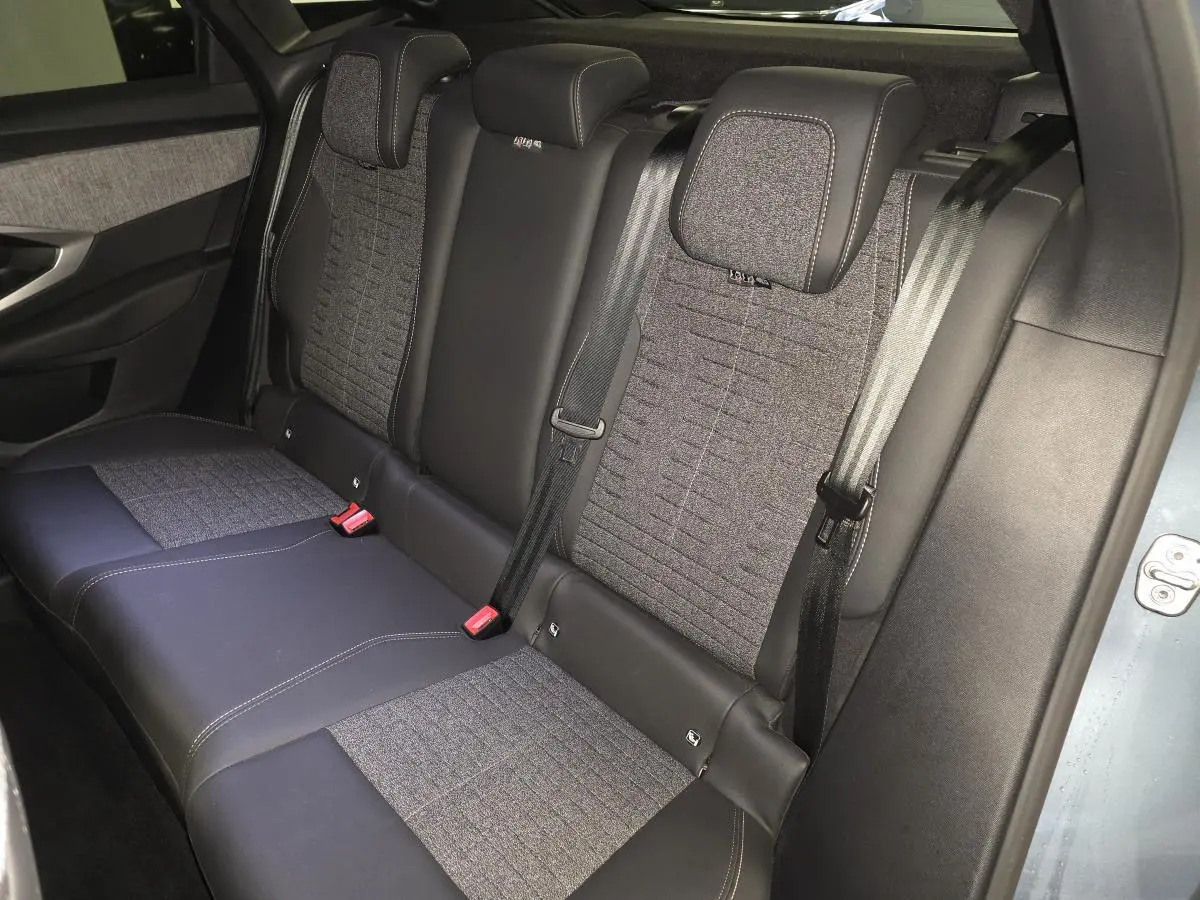Vue côté droit des sièges arrière bi-matière gris tissu et noir cuir du Peugeot 3008 Hybrid 2025 bleu.