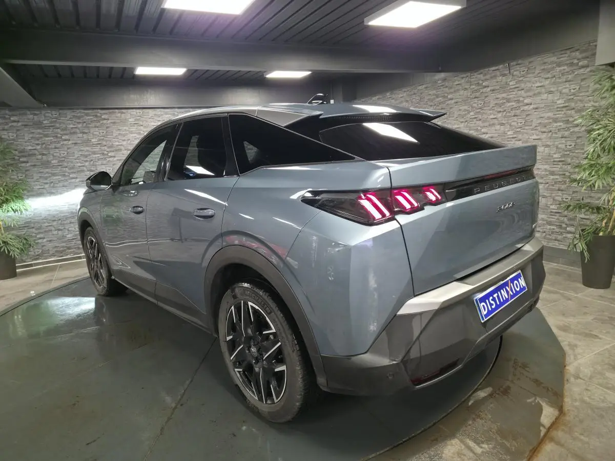 Vue 3/4 arrière droite d’un Peugeot 3008 bleu métallisé avec feux arrière à LED en forme de griffes et jantes alliage noires.