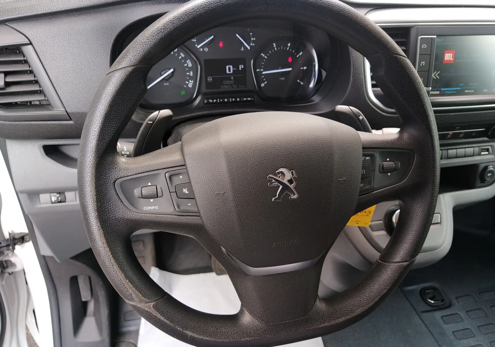 Vue rapprochée du volant noir du Peugeot Expert Fourgon 2020 avec tableau de bord et écran multimédia visibles.