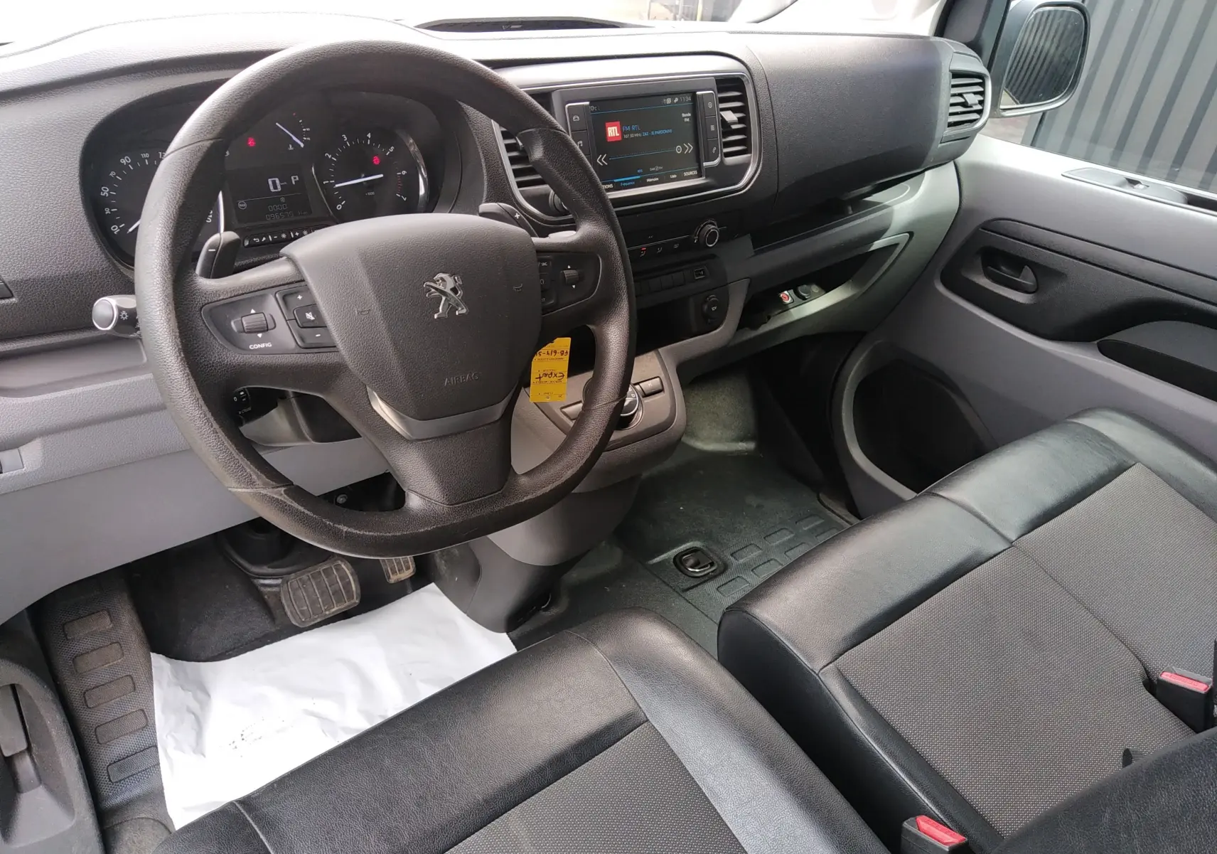 Vue intérieure côté conducteur du Peugeot Expert Fourgon 2020, tableau de bord avec écran tactile et sièges en tissu noir.